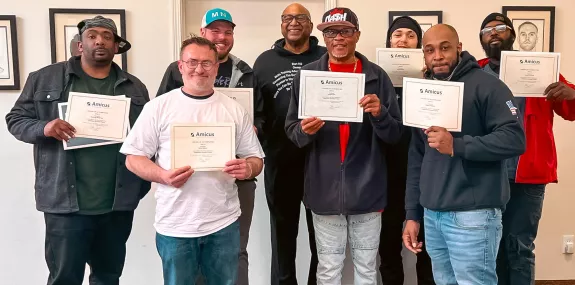 a diverse group of men holding certificates and posing for a photo