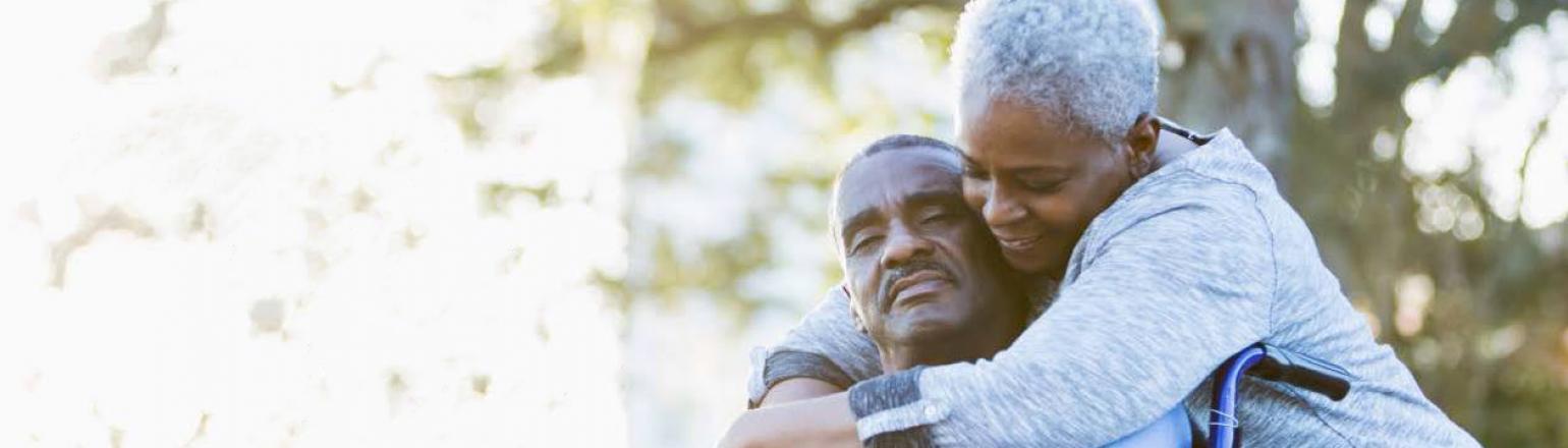 woman hugging man in wheel chair